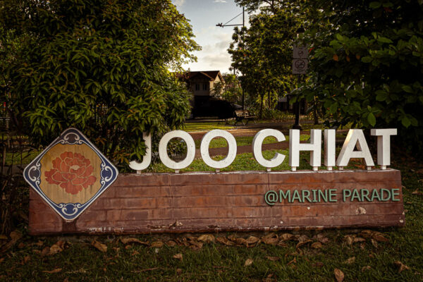 Joo Chiat in large white letters surrounded by a small park at sunrise.